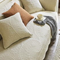 Botanical cotton couch cover arranged across a sofa