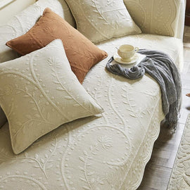 Botanical cotton couch cover arranged across a sofa