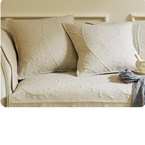 Beige botanical couch cover styled with cushions