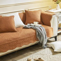 Orange couch cover with a scalloped front edge